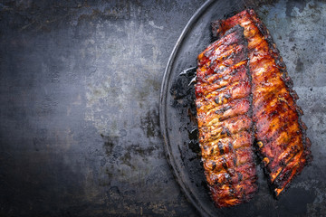 Barbecue pork spare ribs as top view on an old rustic board