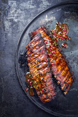 Barbecue Pork Spare Ribs with fruit relish as top view on an old rustic board - obrazy, fototapety, plakaty