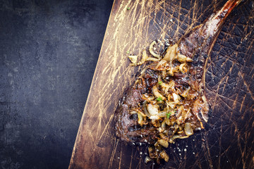 Barbecue dry aged Wagyu Tomahawk Steak as close-up on old wooden board