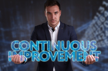 The concept of business, technology, the Internet and the network. Young businessman showing inscription: Continuous improvement