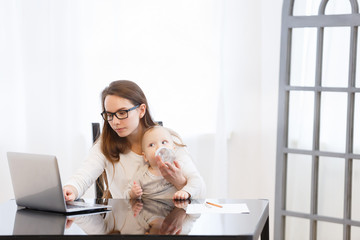 young mother combines education baby and work at home or training at universitye. Childcare and work concept