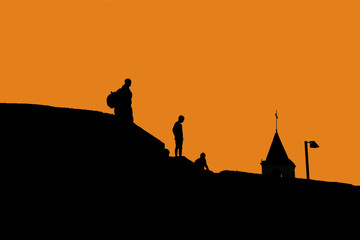 Naklejka premium Silhouettes of people on the roof of houses. 