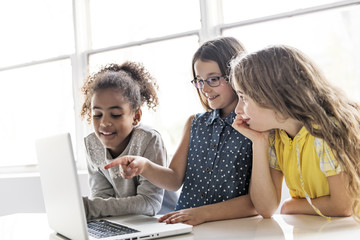 Group of curious children watching stuff on the laptop screen