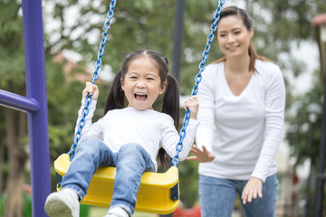 Mom is playing with her little daughter on a terrace with swings. Family lifestyle Concept....