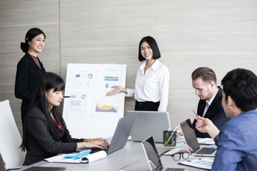Asian Business Woman presenting her work with team at the meeting room, People working Concept.