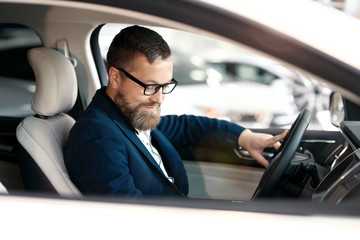 Buyer looking at car interior. Car dealership.