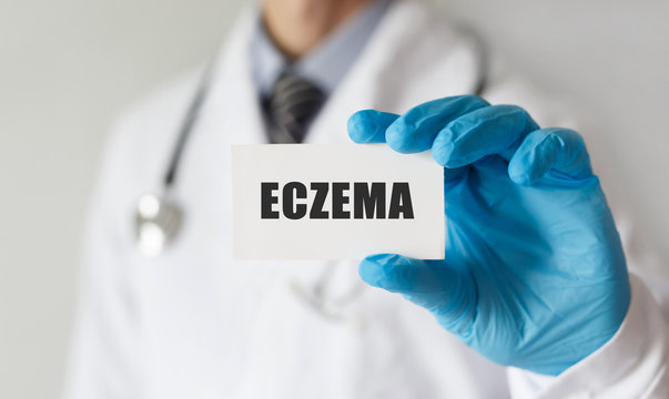 Doctor holding a card with text ECZEMA, medical concept