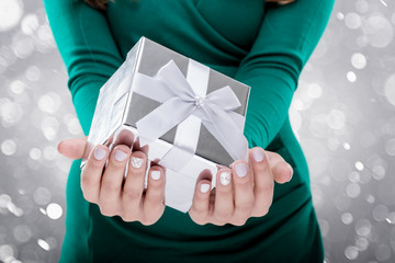 Woman holding a gift box. Close-up shot
