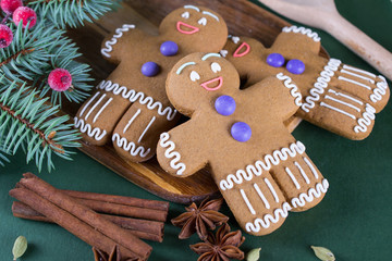 Christmas and holiday baking . Ginger men cookies with décor on  green  background.