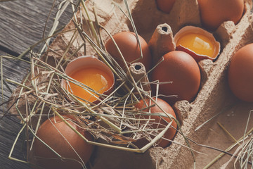 Fresh chicken brown eggs in carton on rustic wood background