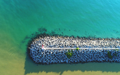 Aerial view. A waves breaker is constructed to allow boats harboring at jetty
