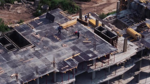 Aerial view of the construction of a high residential house by a construction crane.
