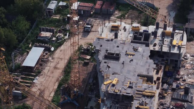Aerial view of the construction of a high residential house by a construction crane.