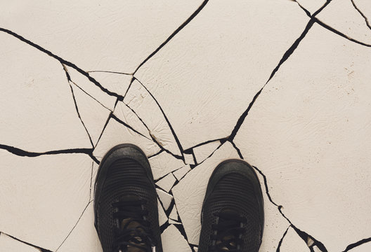 Black shoes on cracked floor copy space