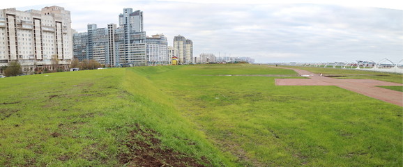 panorama of the city quarter on the coast, green grass, space, morning sky