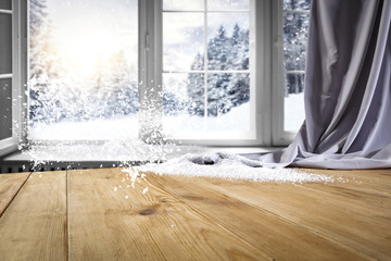 Wooden table with space for your product. Curtain in the window. Open window with snowflakes....