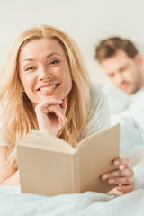 woman with book in bed