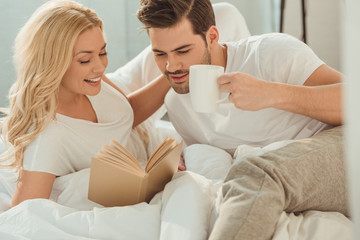 Obraz na płótnie Canvas couple drinking coffee in bed