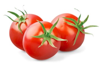 three fresh tomatoes with green leaves isolated on white