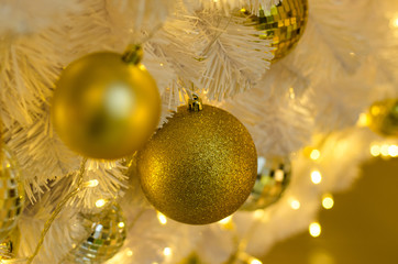 gold White Christmas decoration with balls on fir branches with blurred background