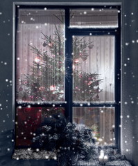 Christmas tree through the evening window. Winter background. Christmas background. Christmas window