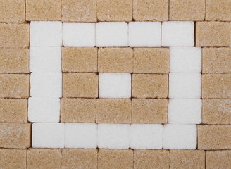 Brown cane and white sugar cubes background and texture