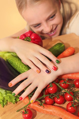 Девочка с разноцветным дизайном ногтей на фоне овощей. - obrazy, fototapety, plakaty