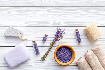 Set for foot spa with lavender. Flowers, spa salt, pumice stone, soap on white wooden background top view copyspace