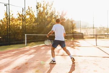 Foto op Canvas  Man playing tennis in the morning in sunlight © diignat