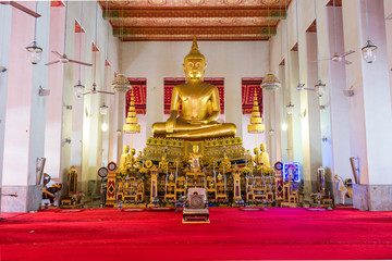 Large golden Buddha in lotus position in the Buddhist temple and monastery Wat Mahathat Yuwaratrangsarit. It is one of the 10 royal temples of the highest class in Bangkok
