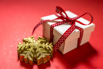 White gift box with red ribbon isolated on red color background. Merry Christmas and Happy Holidays concept.