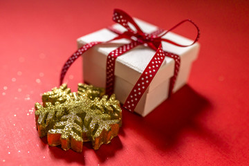 White gift box with red ribbon isolated on red color background. Merry Christmas and Happy Holidays concept.