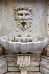 Fontaine en marbre à tête grotesque à Pise en Italie, France