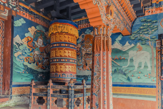 Wall paintings and large prayer wheel inside the portico of the Trongsa Dzong, Bumthang, Bhutan.