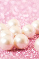 Obraz na płótnie Canvas Pile of pearls on pink festive background 
