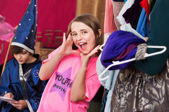 Girl in dressing room poses with hands by face
