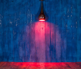 projecteur de lumière rouge sur un mur en bois bleu