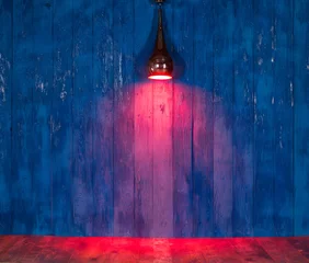 Photo sur Plexiglas Lumière et ombre projecteur de lumière rouge sur un mur en bois bleu