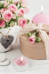 Pink roses in concrete pot with candle