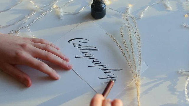 Drawn calligraphy on white paper with nib pen.