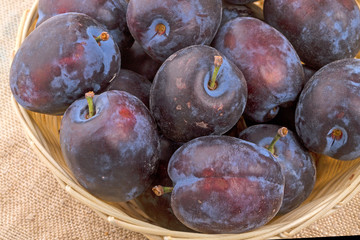 Large plums in a wicker bowl