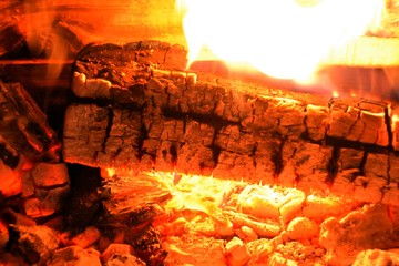Kaminfeuer mit grell brennendem Holz in rot, gelb und orange