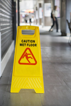 yellow sign inside building hallway showing warning of caution wet floor,selective focus,vintage color.