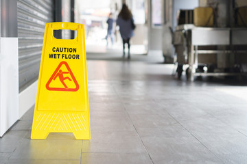 yellow sign inside building hallway showing warning of caution wet floor,selective focus,vintage...