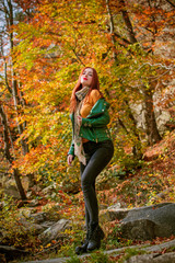 Beautiful hipster traveler with around autumn trees in woods. Stylish woman hiking. adventure and travel concept or rest at weekend on a nature, atmospheric moment