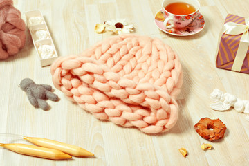 Handmade knitwear composition with warm hat of pastel color