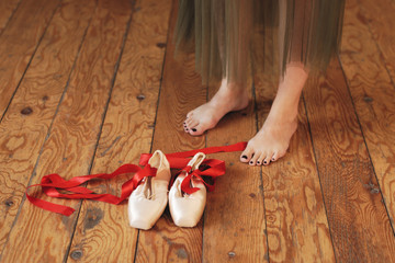 Ballerina putting ballet shoes on