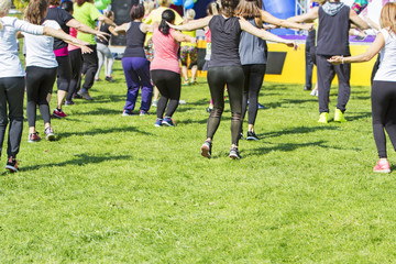 Fototapeta premium Group of young girls exercising fitness with dancing in the city park