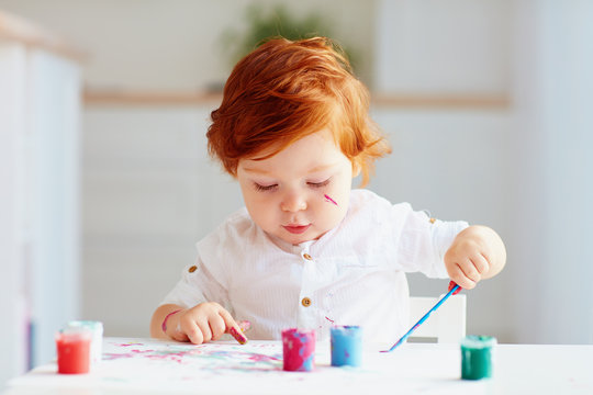 Happy Little Baby Artist Drawing With Colorful Paints At Home