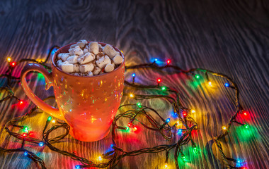 Christmas composition with cup of cocoa and marshmallows and lig